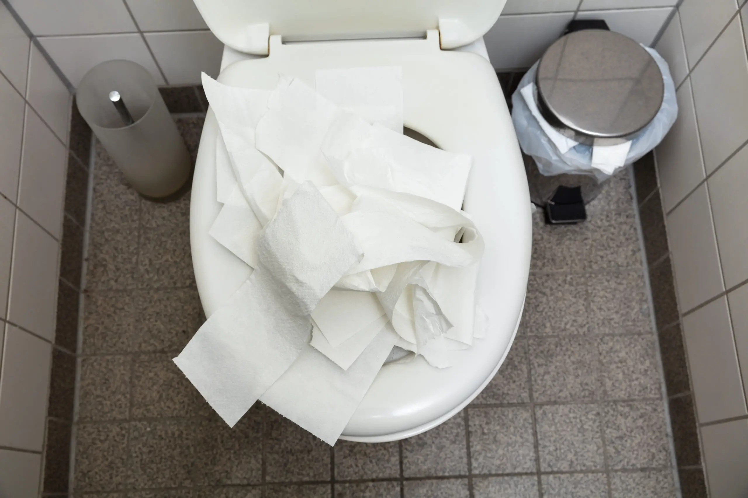 An Overhead View Of Used Crumpled White Toilet Paper Inside The Toilet Bowl