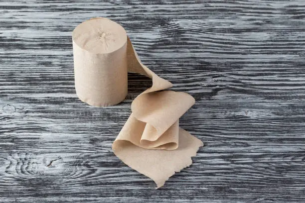 Eco-friendly toilet paper made from recycled paper on wooden background