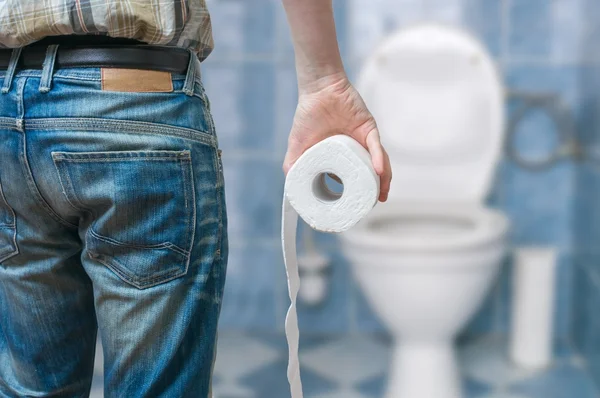 Man suffers from diarrhea holds toilet paper roll in front
