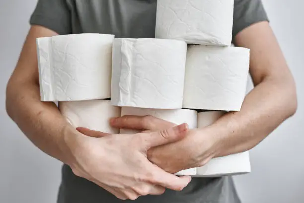 Woman holds many rolls of toilet paper