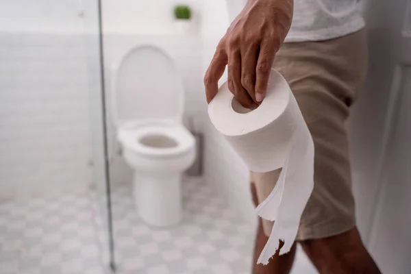 Hand holding toilet paper before using it