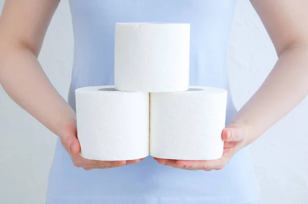 Rolls of toilet paper in the hands of a Caucasian woman