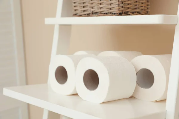 Toilet paper rolls on shelving unit in bathroom