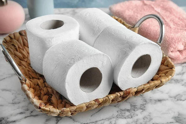Wicker tray with toilet paper rolls on table