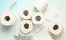 Rolls of toilet paper on light blue background